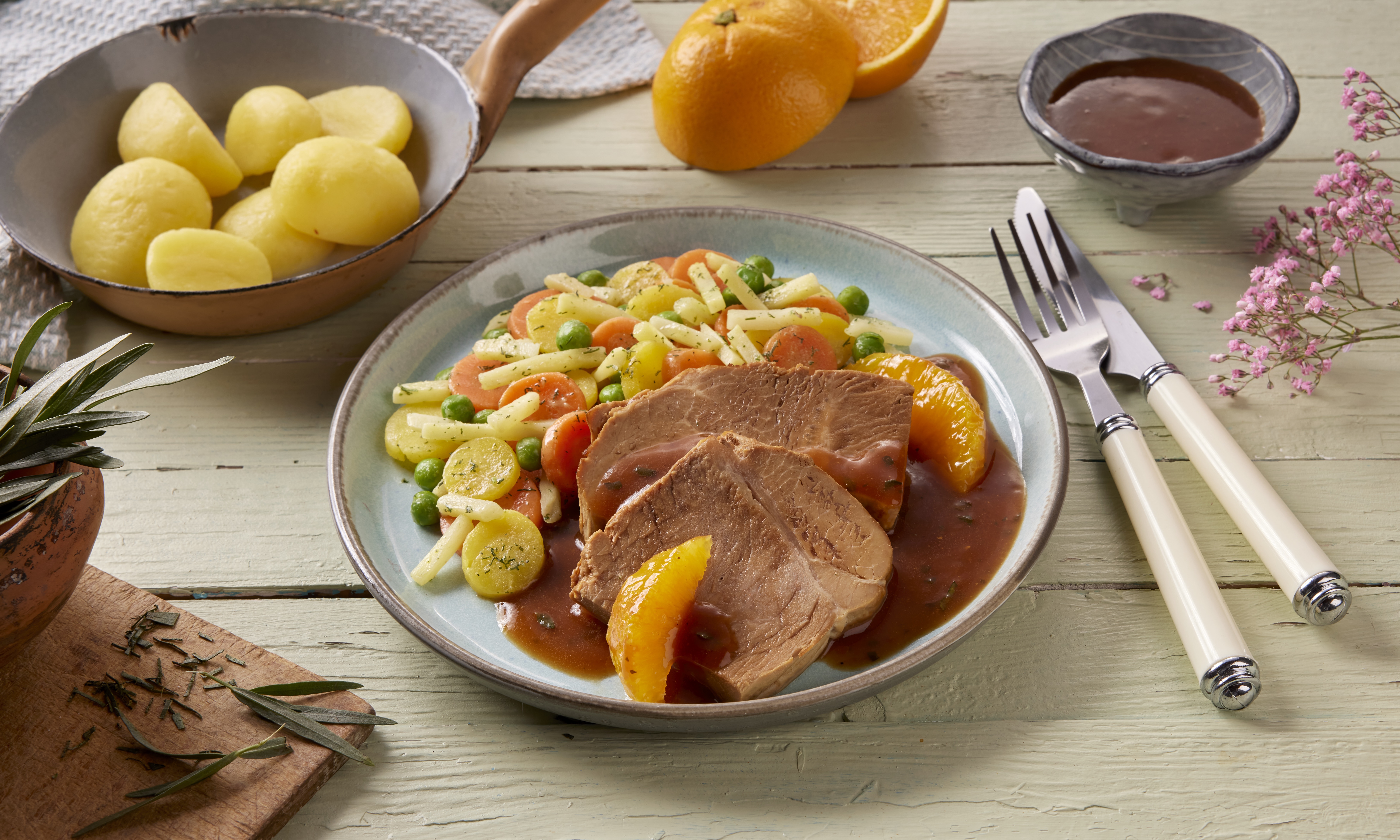 Frühlingsgericht: Kalbsbraten mit Orangensoße, Gemüse und Kartoffeln angerichtet