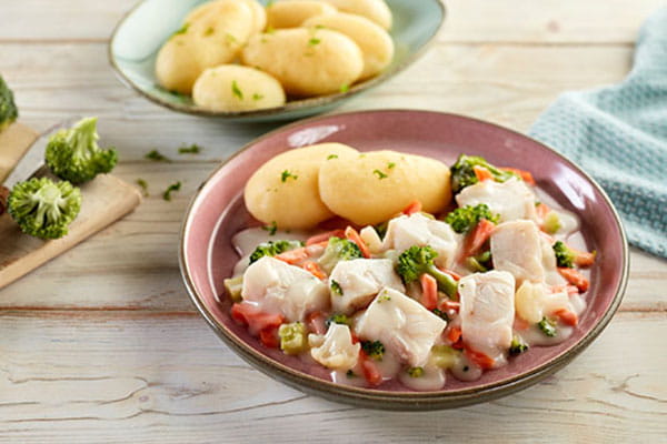 Fischfilet mit Brokkoli, Karotten und heller Soße, serviert mit Kartoffeln