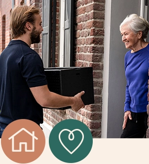 Ein Menükurier liefert Menüs an eine Seniorin aus