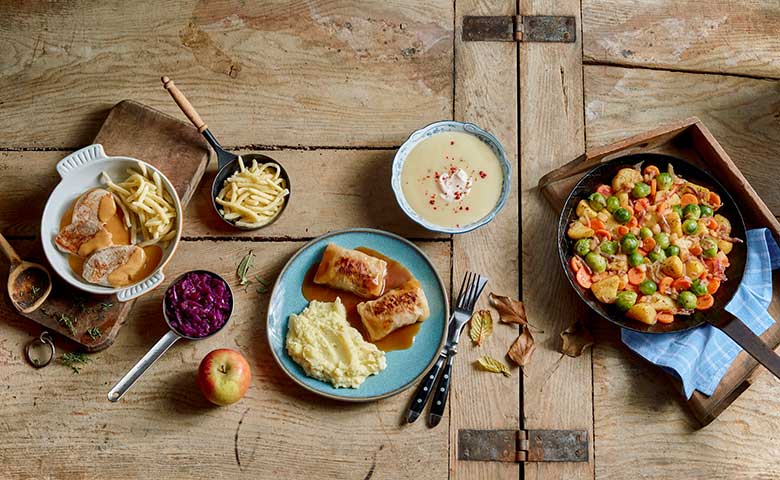 abwechslungsreiche Gerichte, angerichtet auf einem großen Holztisch