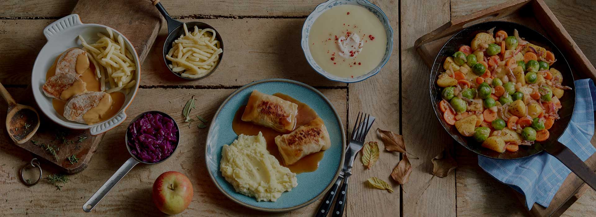 abwechslungsreiche Gerichte, angerichtet auf einem großen Holztisch
