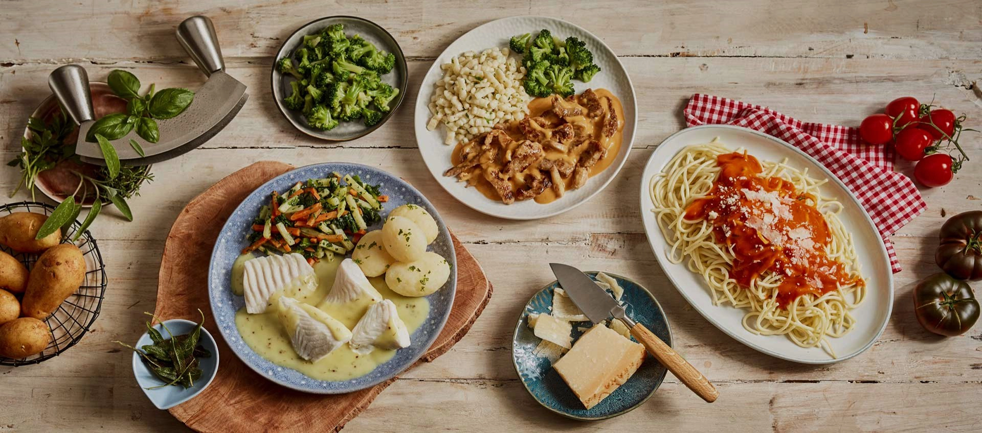 abwechslungsreiche Gerichte mit Beilagen, angerichtet auf einem großen Holztisch