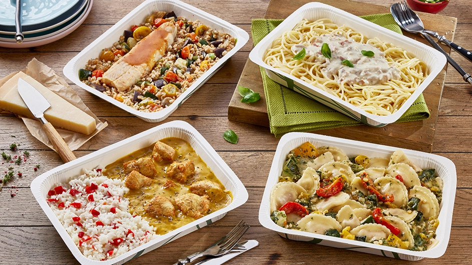 Vier verschiedene Menüschalen mit Reis, Pasta, Teigtaschen und Gemüse