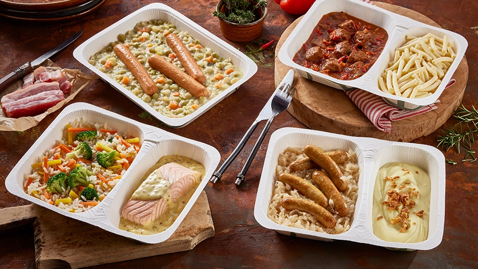 Vier Menüschalen mit Würstchen, Gulasch, Lachs und Gemüse