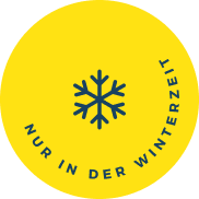Gelber runder Button mit dunkelblauer Schneeflocke in der Mitte und umlaufendem Text „NUR IN DER WINTERZEIT“.